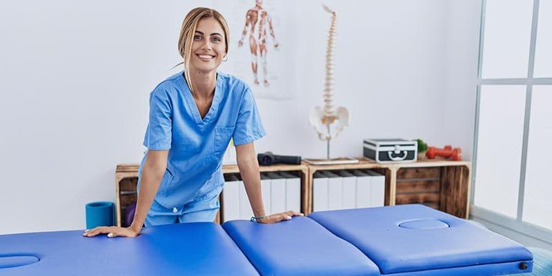 Woman leaning on physical therapy table