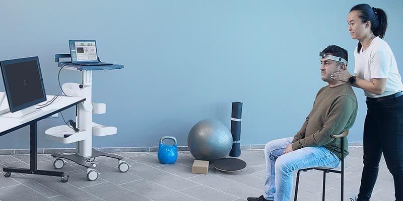 man being tested using functional vision head impulse test